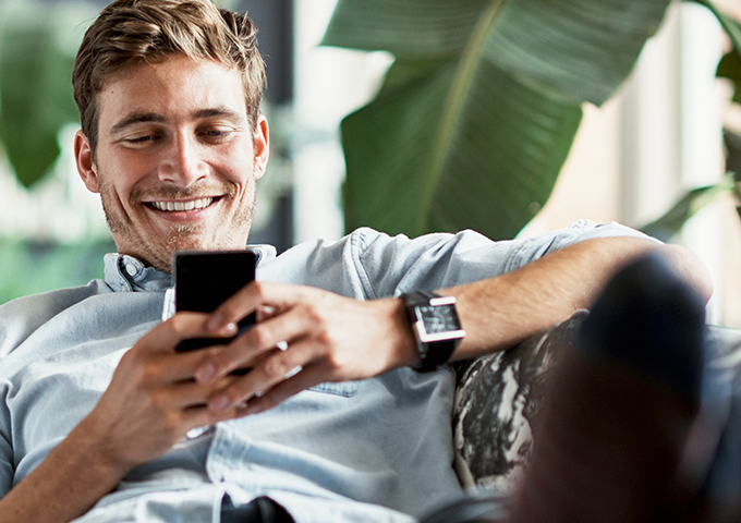 Man-relaxing-with-mobile-phone